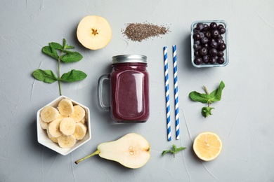 Photo of Flat lay composition with ingredients for delicious acai cocktail and juice in mason jar on gray table