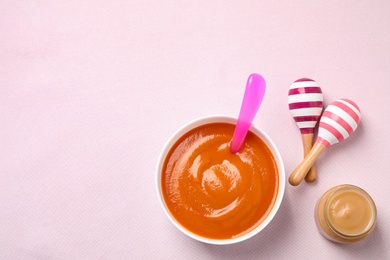 Photo of Healthy baby food and maracas on light background, flat lay. Space for text