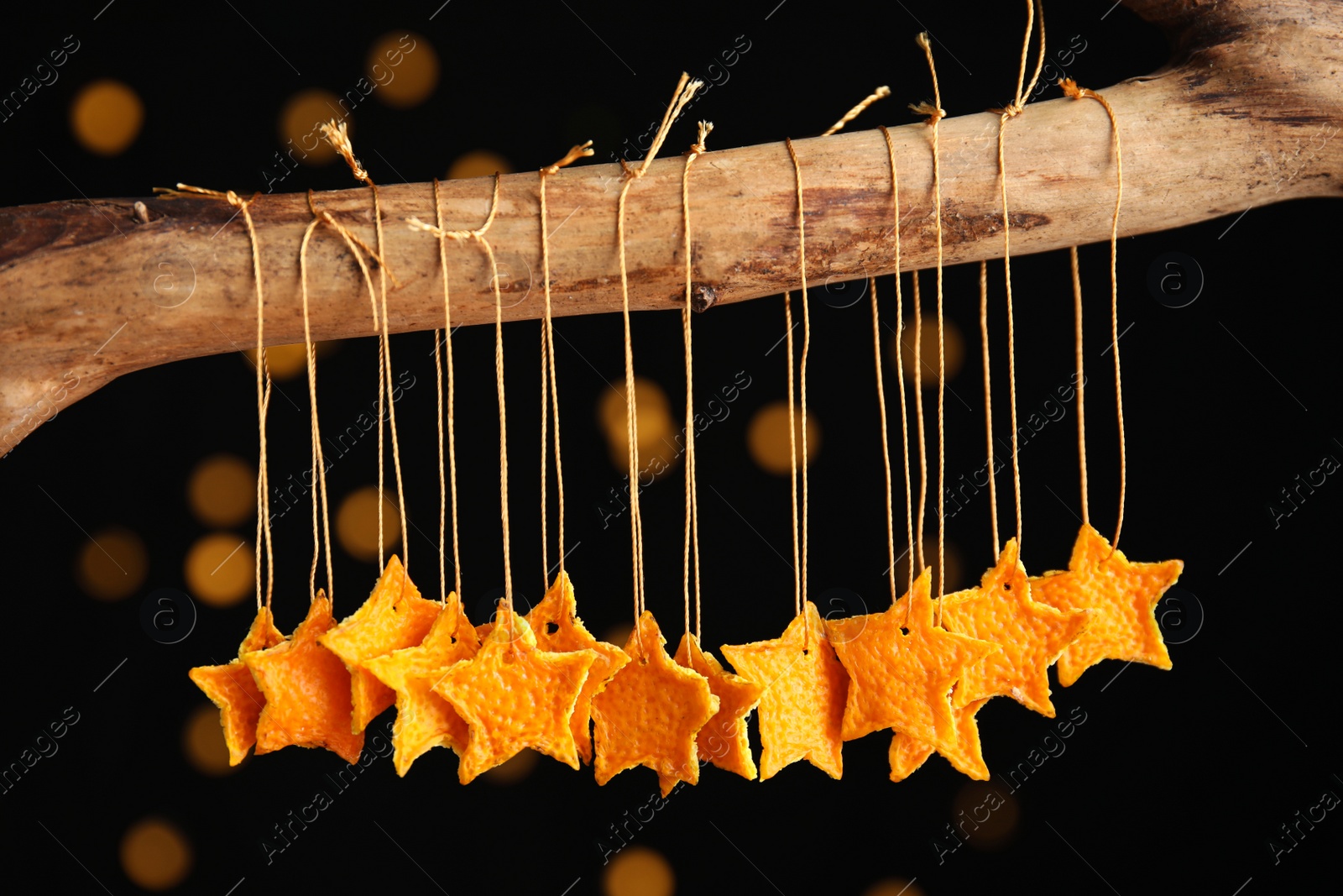 Photo of Stars made of tangerine peel hanging against black background