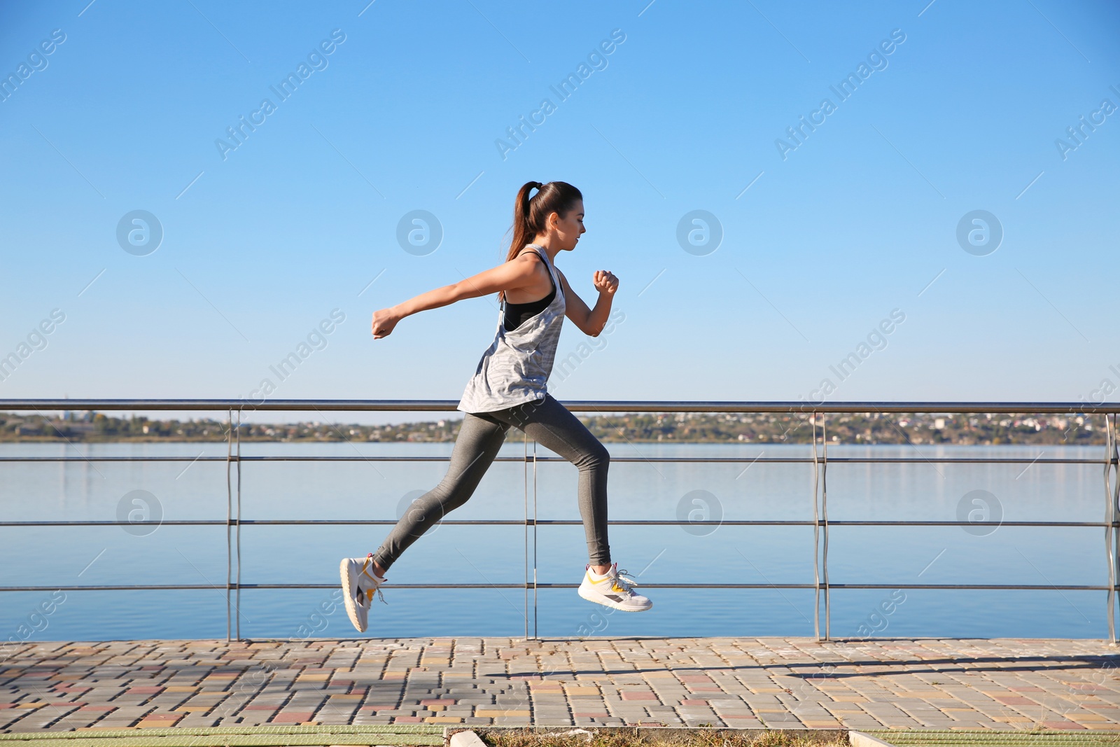 Photo of Sporty woman running outdoors on sunny morning