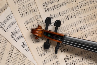 Photo of Classic violin on music sheets, top view