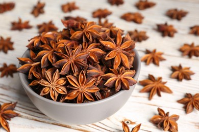 Photo of Many aromatic anise stars on white wooden table