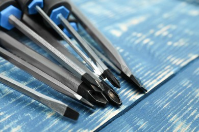 Set of screwdrivers on blue wooden table, closeup. Space for text