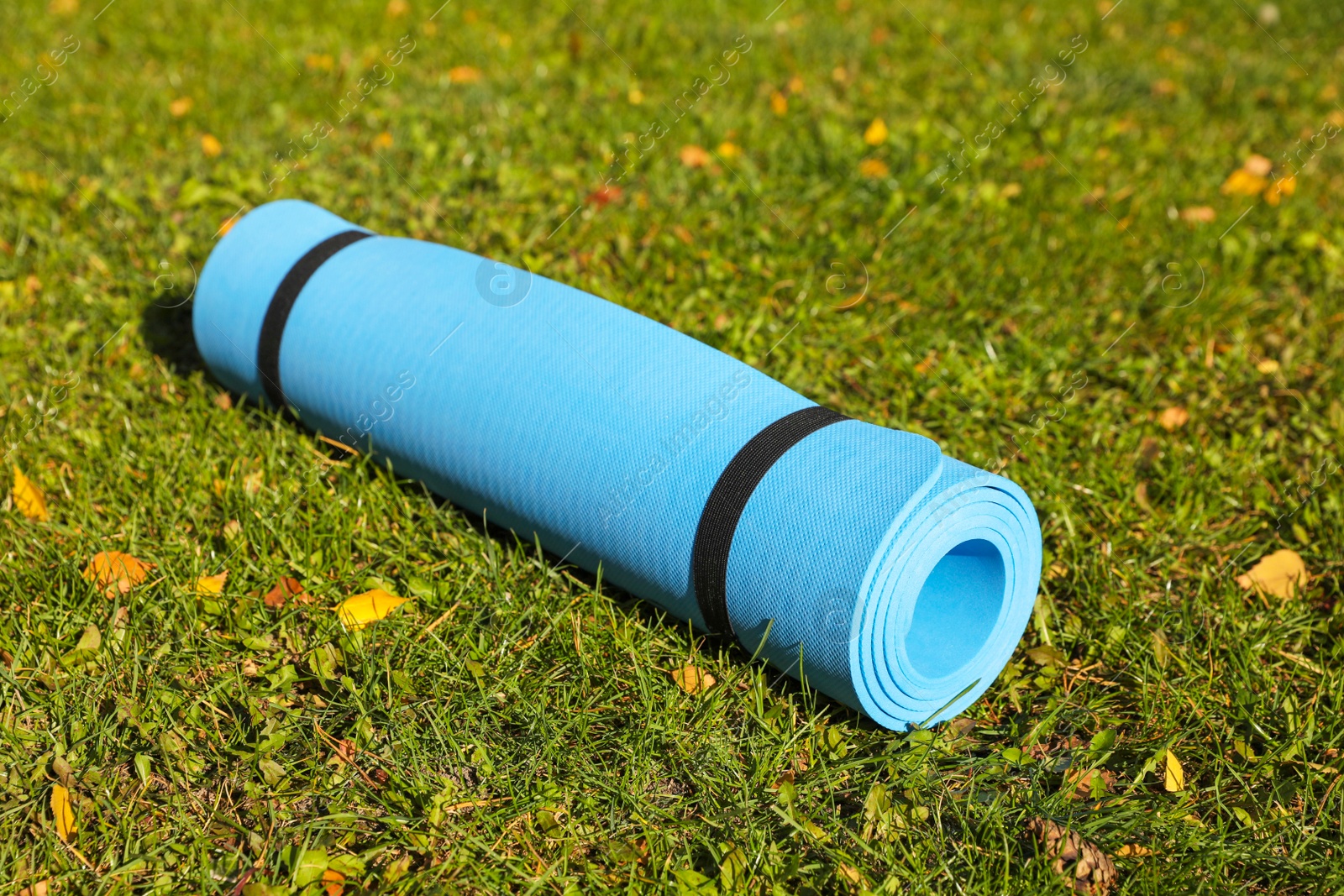 Photo of Blue karemat or fitness mat on fresh green grass outdoors