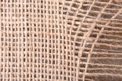 Photo of Piece of burlap fabric on wooden table, top view
