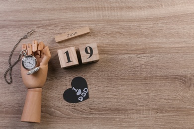 Photo of Composition with calendar and clock on wooden background. Father's day celebration