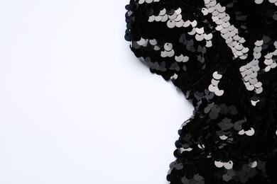 Black shiny sequin fabric on white background, top view. Space for text