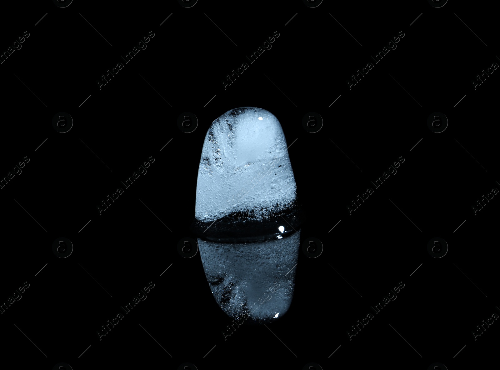 Photo of Melting ice cube on black background. Frozen liquid