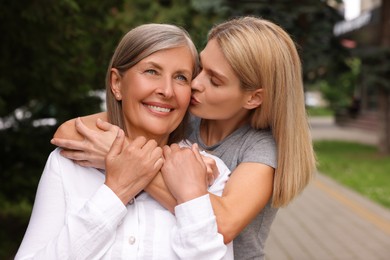 Happy mature mother and her daughter outdoors