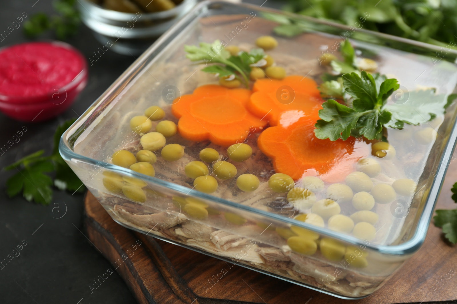 Photo of Delicious aspic with meat on black slate table, closeup