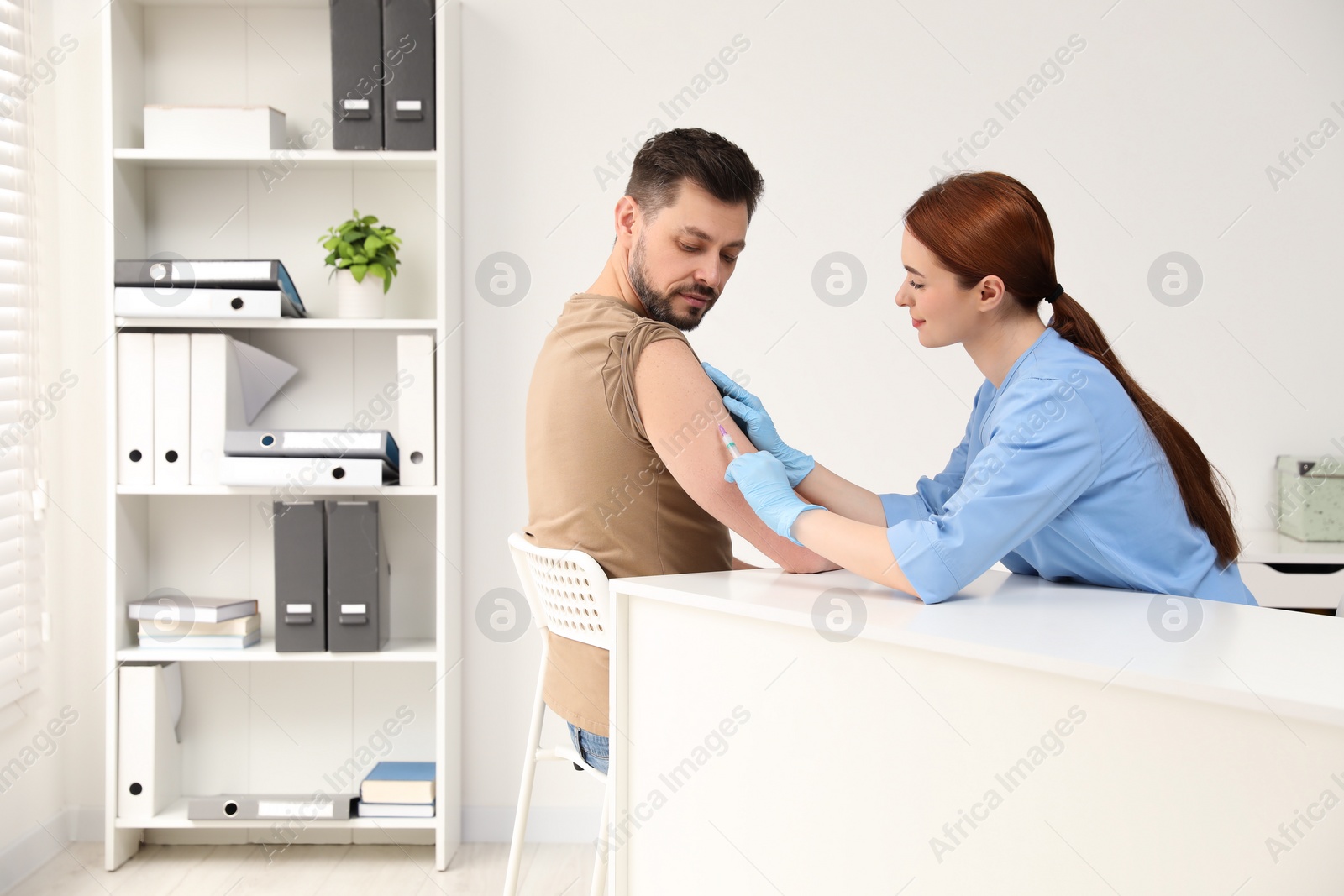 Photo of Doctor giving hepatitis vaccine to patient in clinic