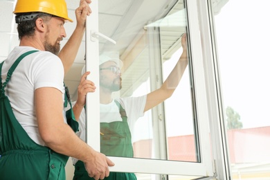 Construction workers installing new window in house