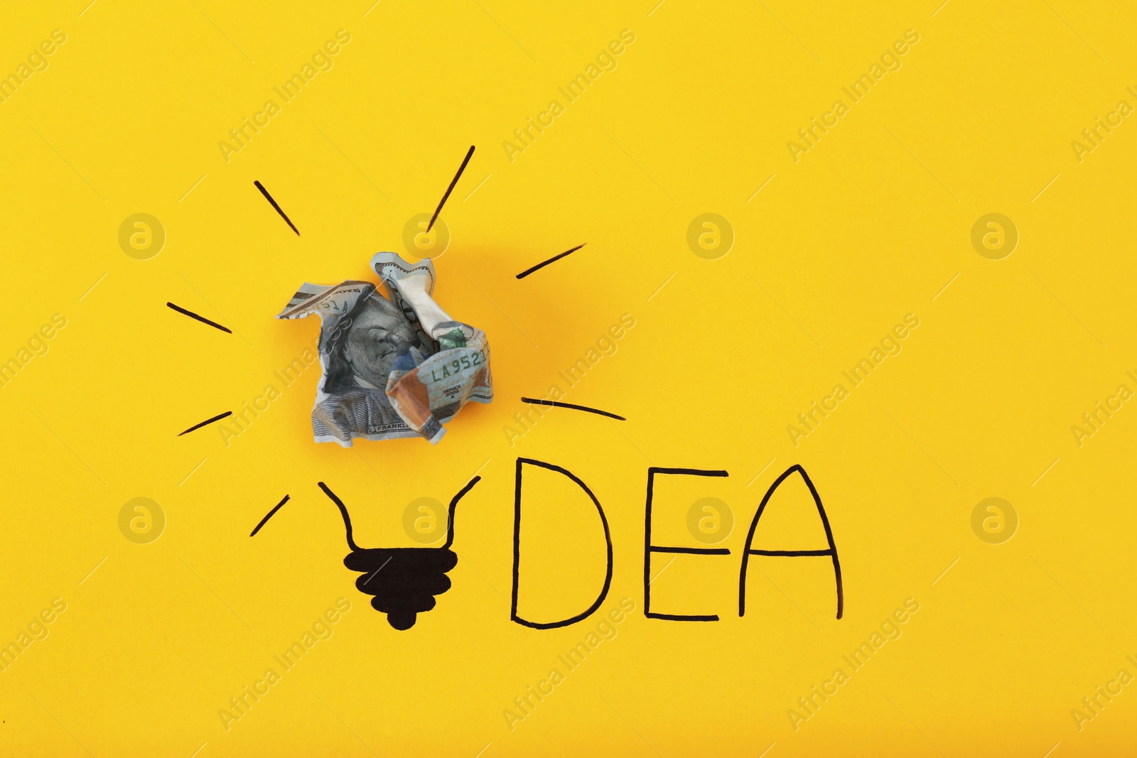 Photo of Composition with crumpled banknote, drawing of lamp bulb and word IDEA on color background. Creative concept