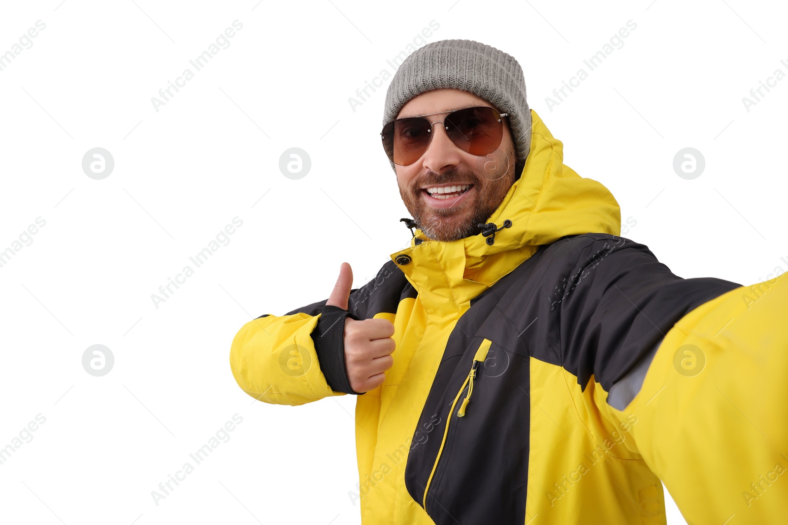 Photo of Smiling man in sunglasses taking selfie and showing thumbs up on white background