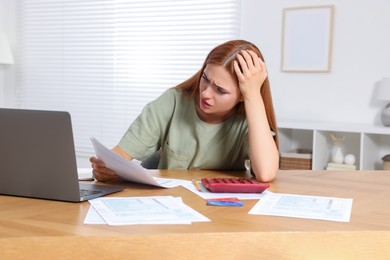 Photo of Woman doing taxes at table in room
