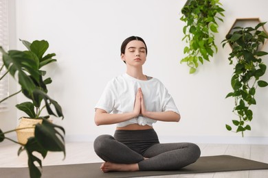 Photo of Beautiful girl meditating on mat in yoga studio