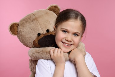 Photo of Cute girl with teddy bear on pink background