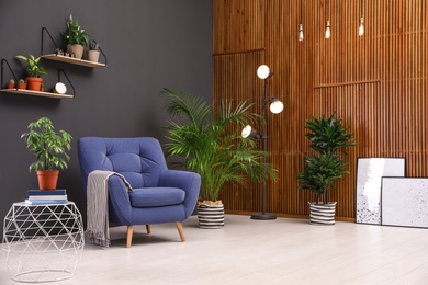 Room interior with armchair and indoor plants. Trendy home decor