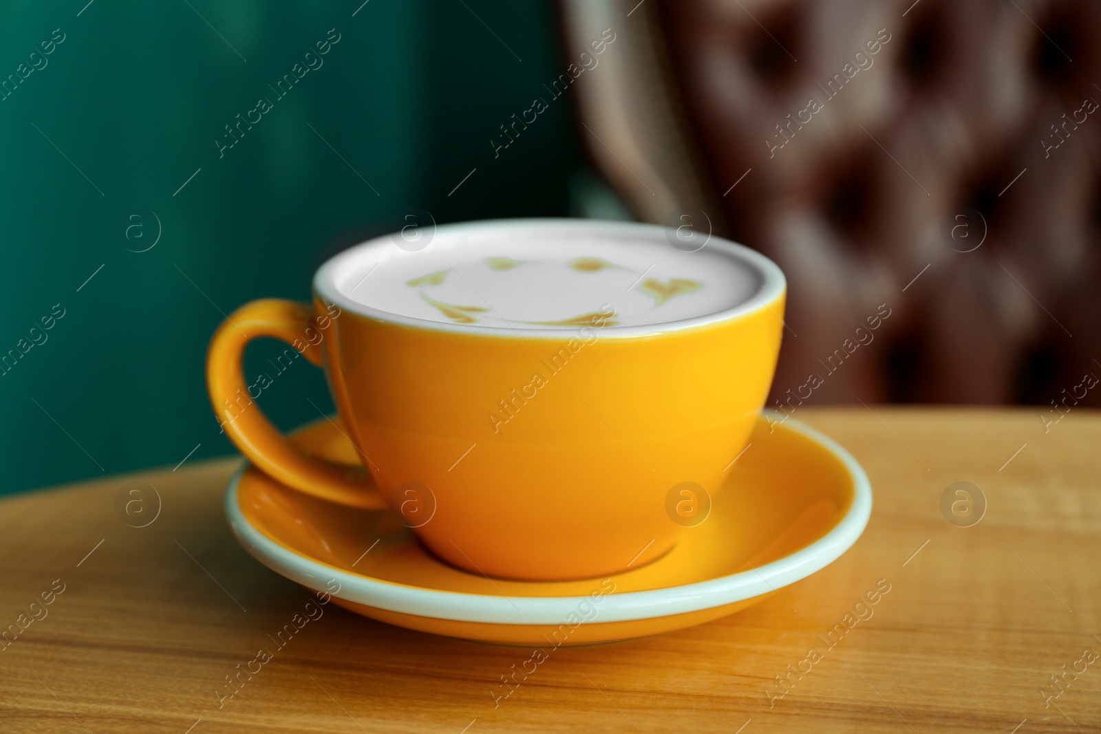Photo of Cup of delicious coffee on wooden table indoors, closeup