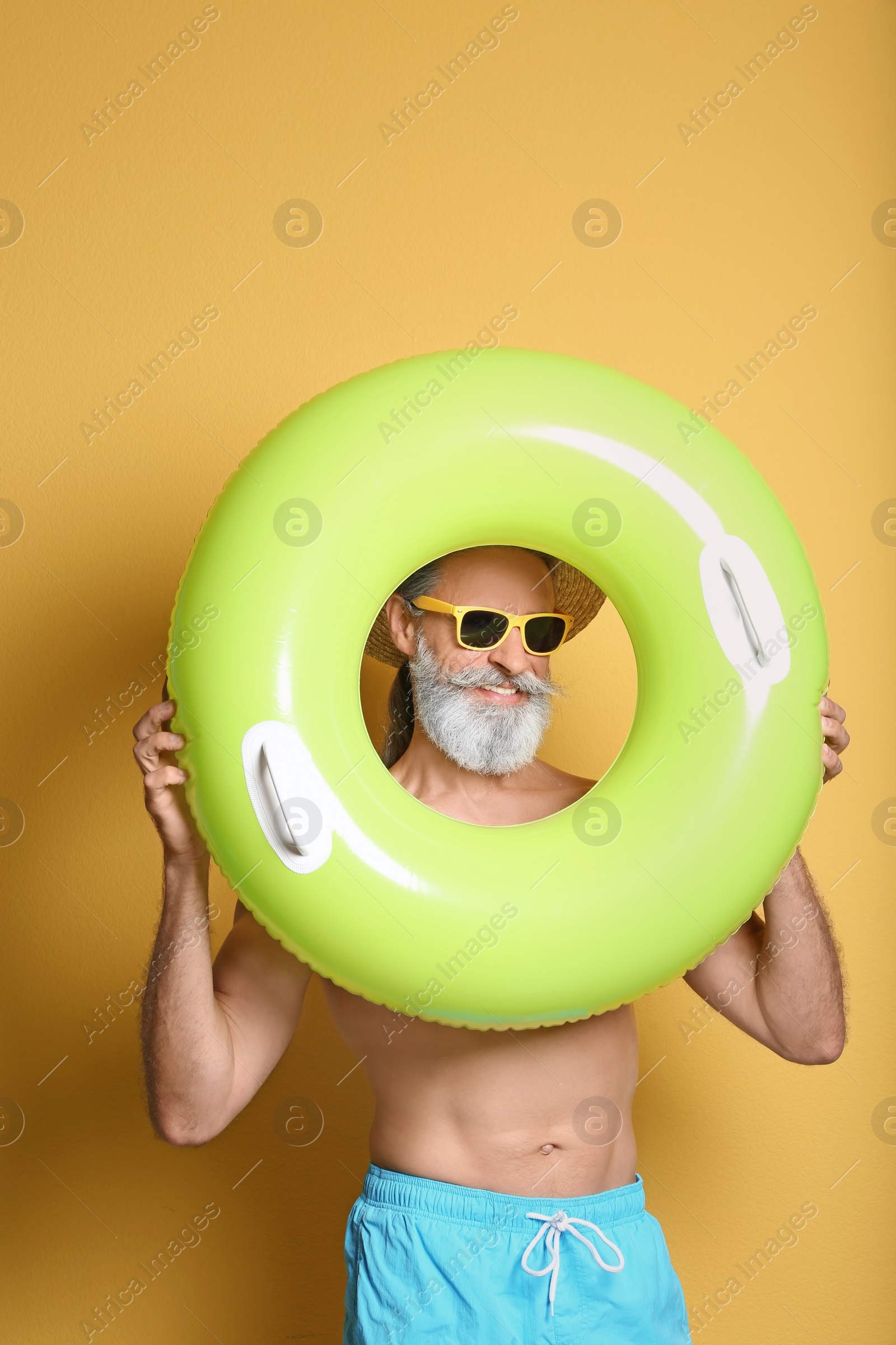 Photo of Shirtless man with inflatable ring on color background