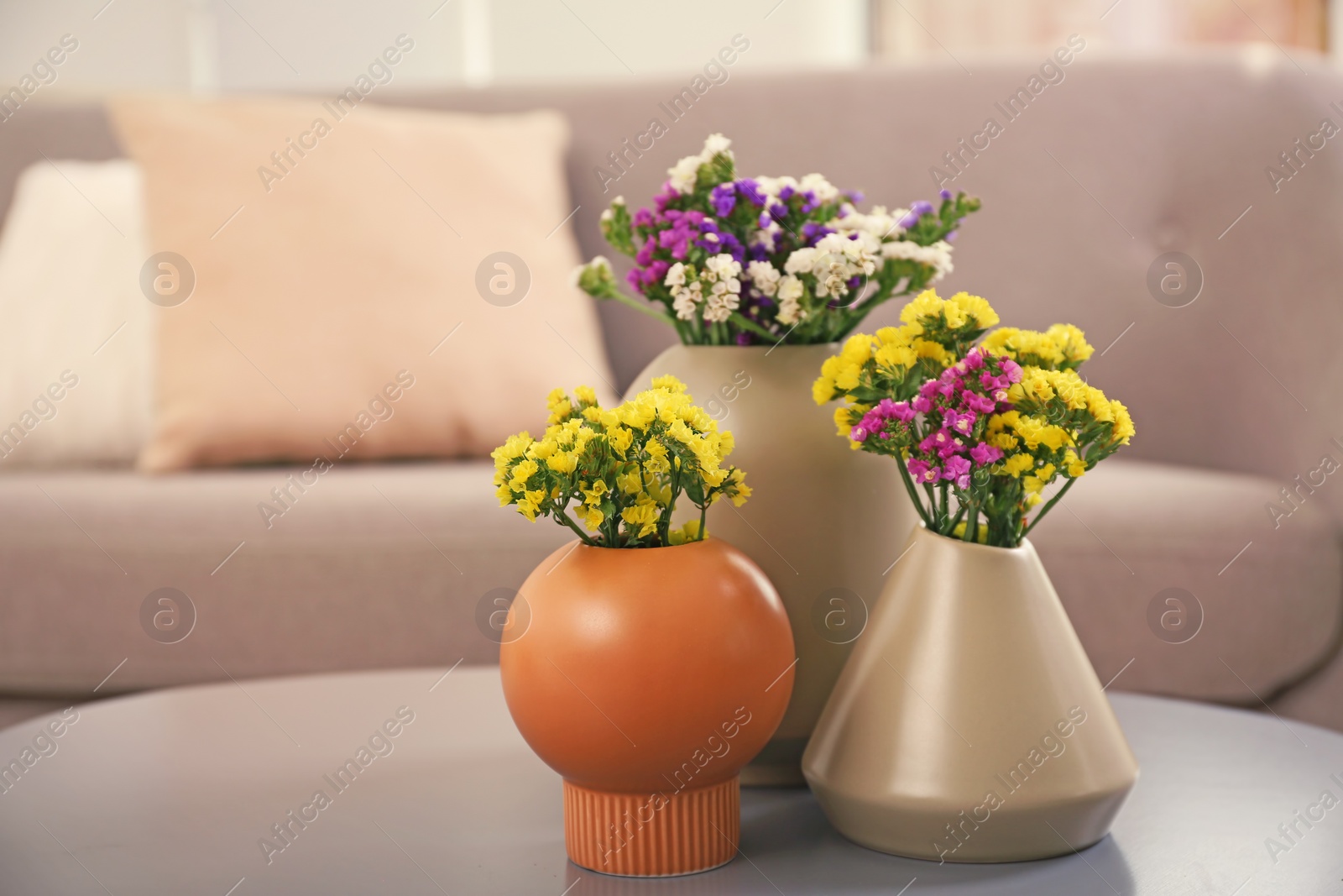 Photo of Beautiful flowers in vases as element of interior design on table. Space for text