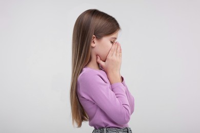 Photo of Sick girl coughing on light background. Cold symptoms