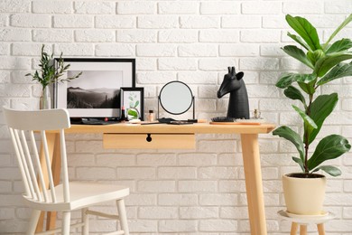 Dressing table with mirror, makeup products and accessories in room