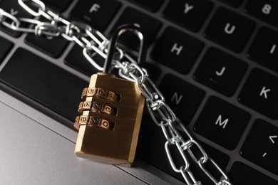 Photo of Cyber security. Padlock with chain on laptop, closeup