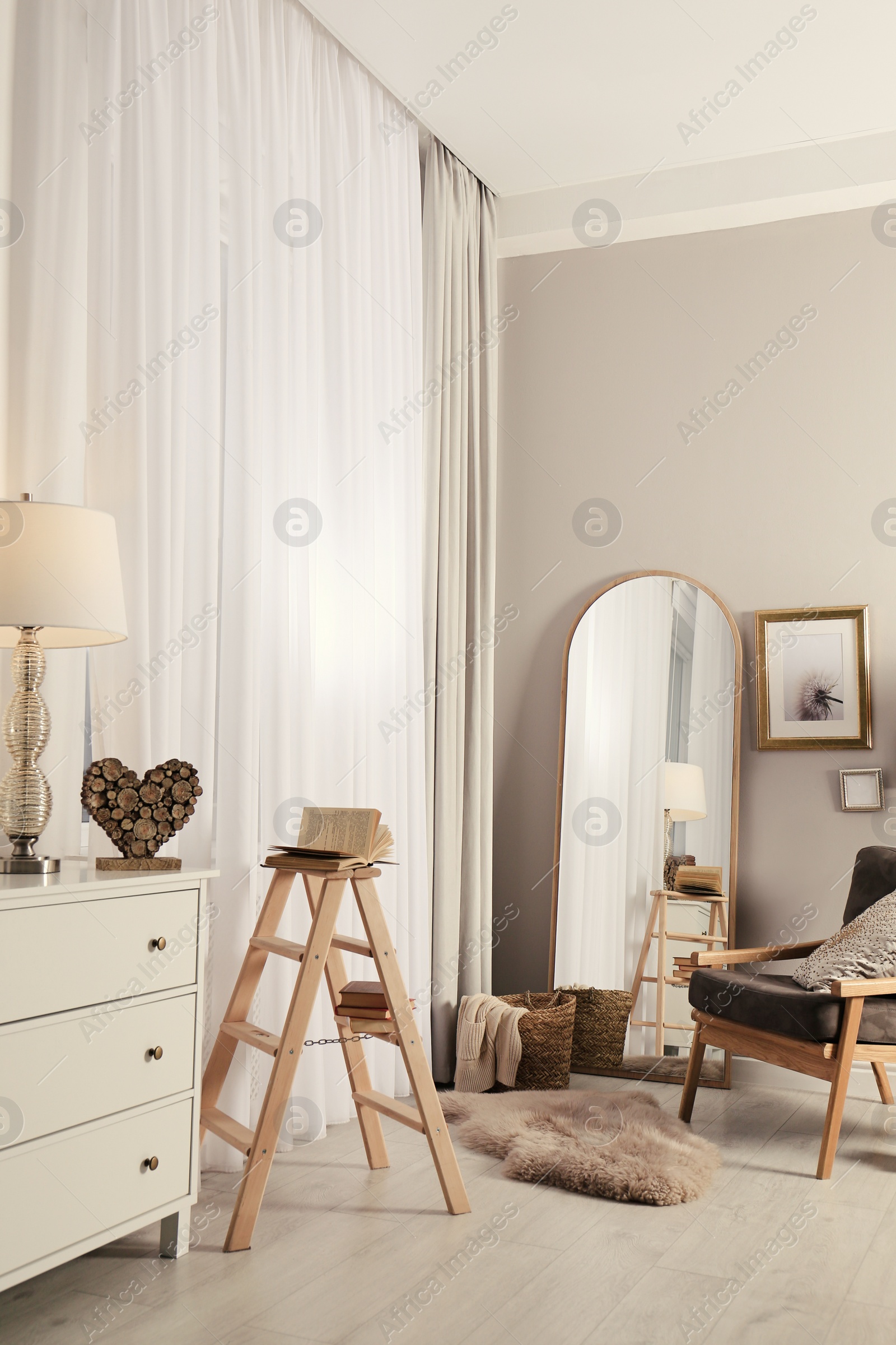 Photo of Stylish room interior with large mirror and comfortable armchair