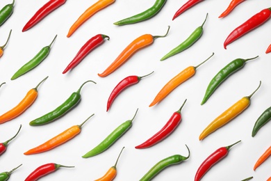 Photo of Different hot chili peppers on white background, top view