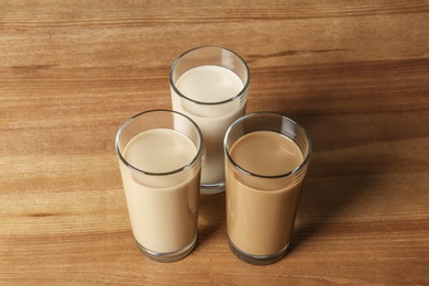 Photo of Glasses with protein shakes on wooden background