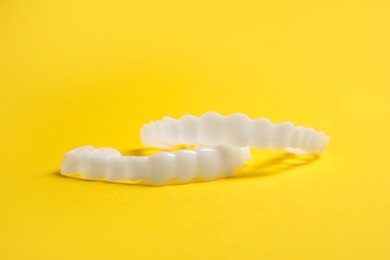Photo of Dental mouth guards on yellow background, closeup. Bite correction