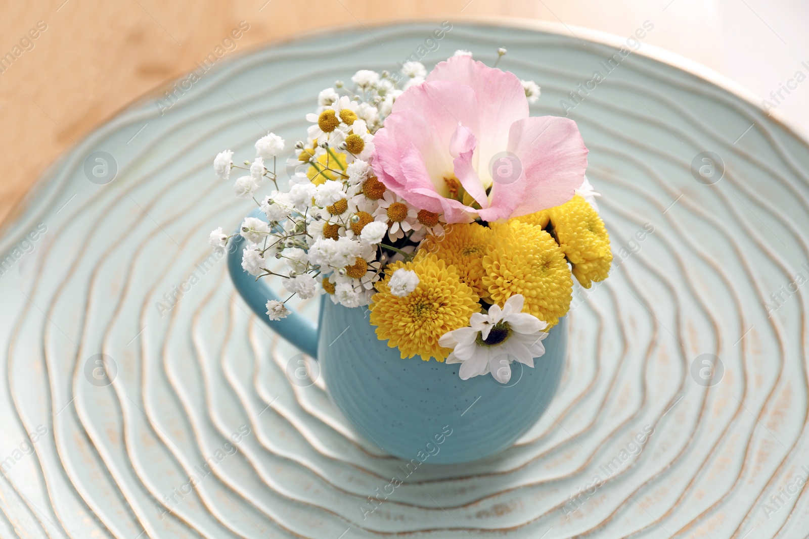 Photo of Beautiful bright flowers in light blue cup