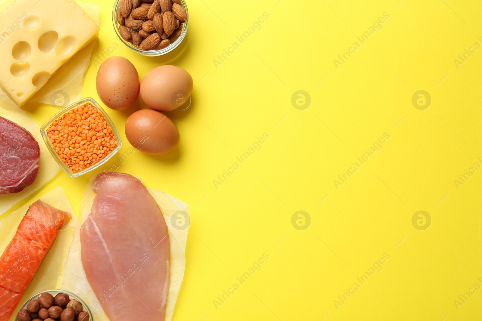 Photo of Set of products rich in amino acids on yellow background, flat lay. Space for text
