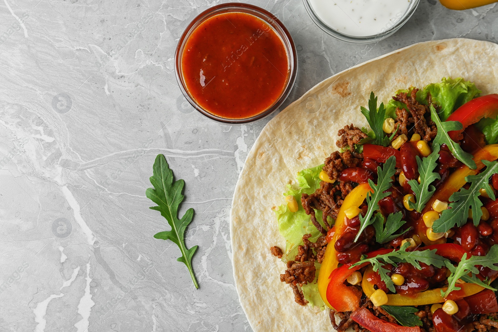 Photo of Delicious tortilla with meat on light table, flat lay. Space for text