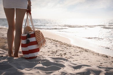 Photo of Woman with beach bag walking near sea, closeup