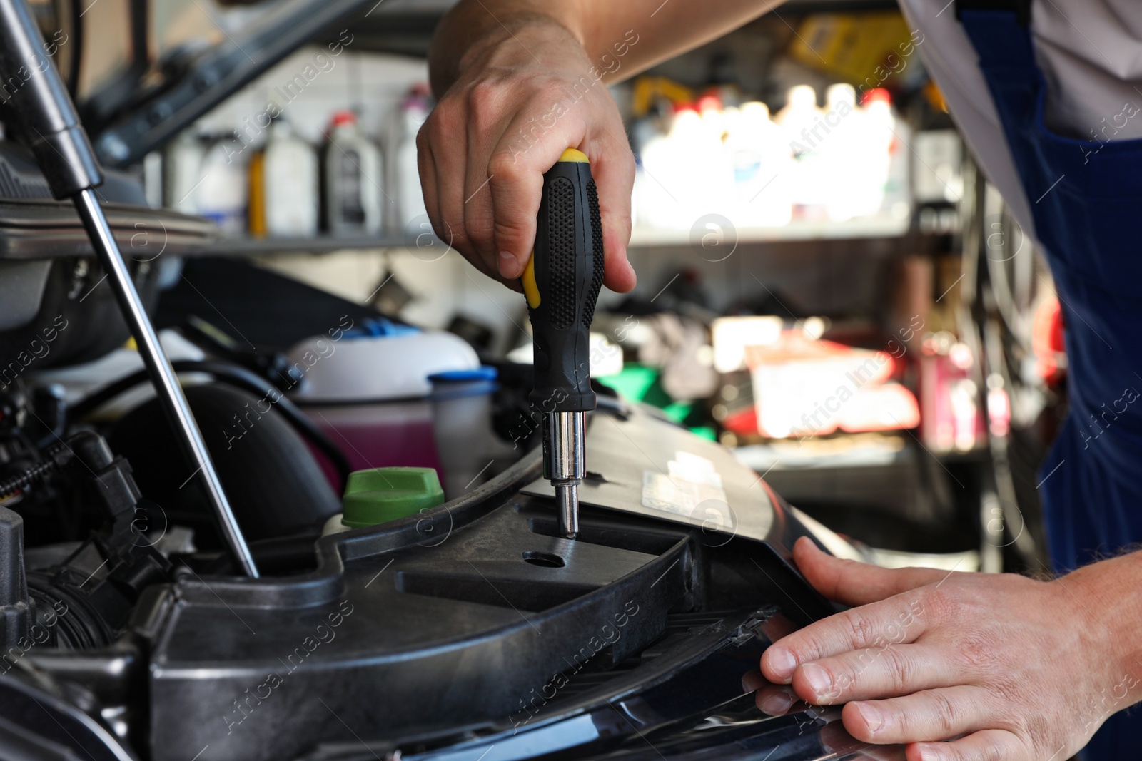 Photo of Professional auto mechanic fixing modern car in service center, closeup