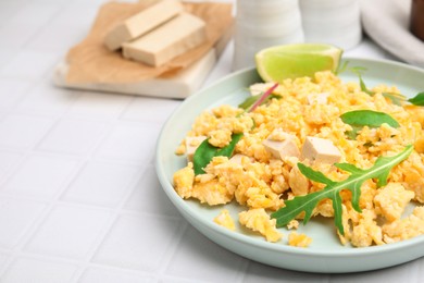 Delicious scrambled eggs with tofu and lime served on white table, closeup. Space for text