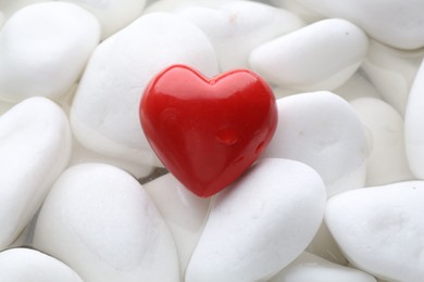 Photo of Red decorative heart on stones and water, top view