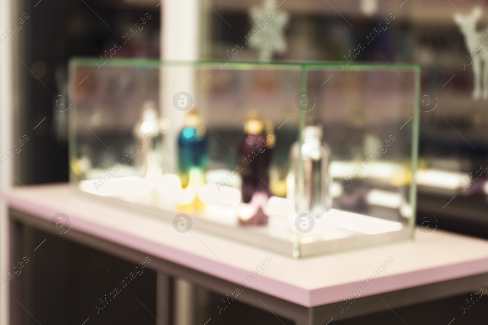 Photo of Blurred view of perfume bottles on stand in shop