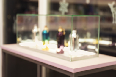 Blurred view of perfume bottles on stand in shop