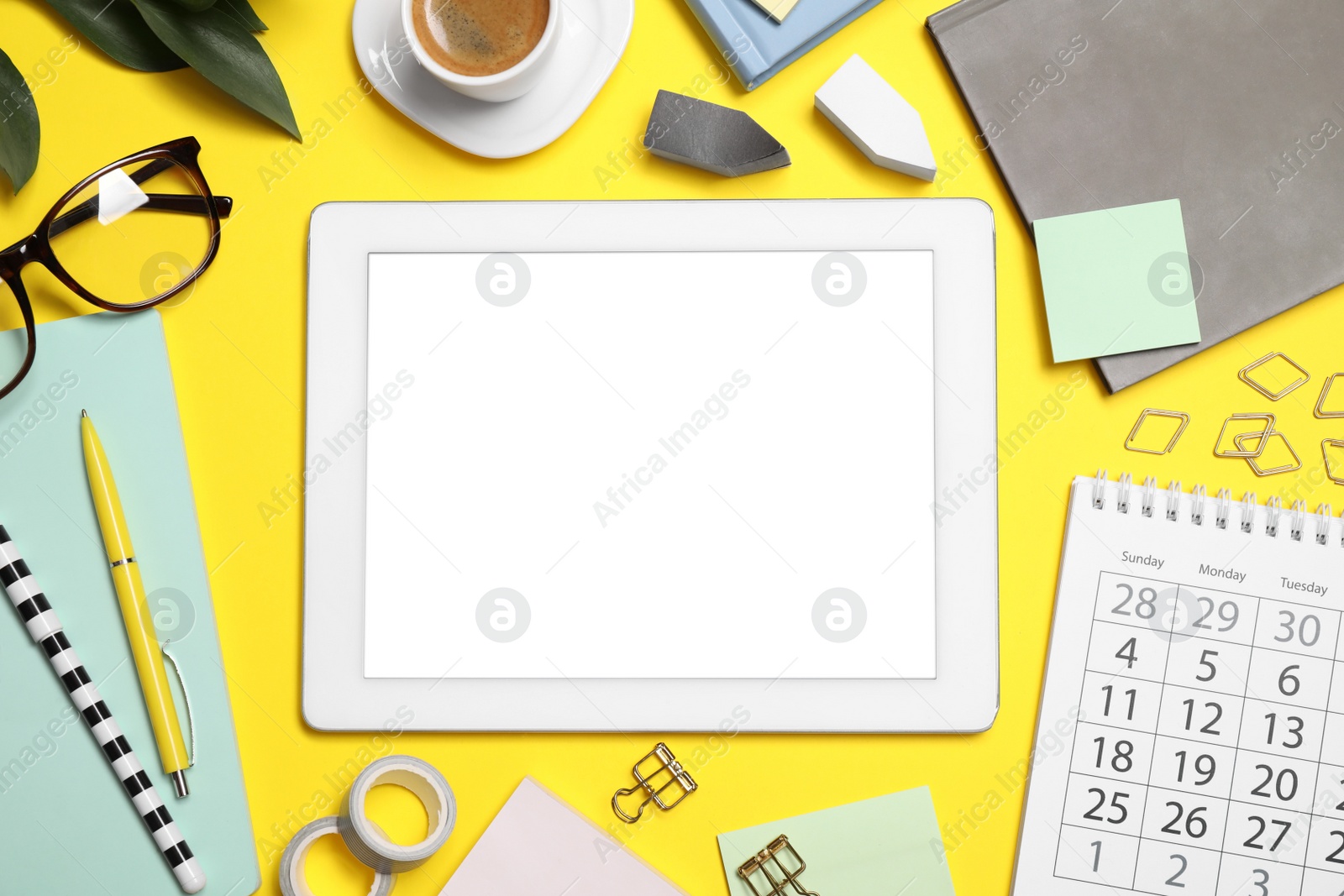 Photo of Flat lay composition with tablet and stationery on yellow background
