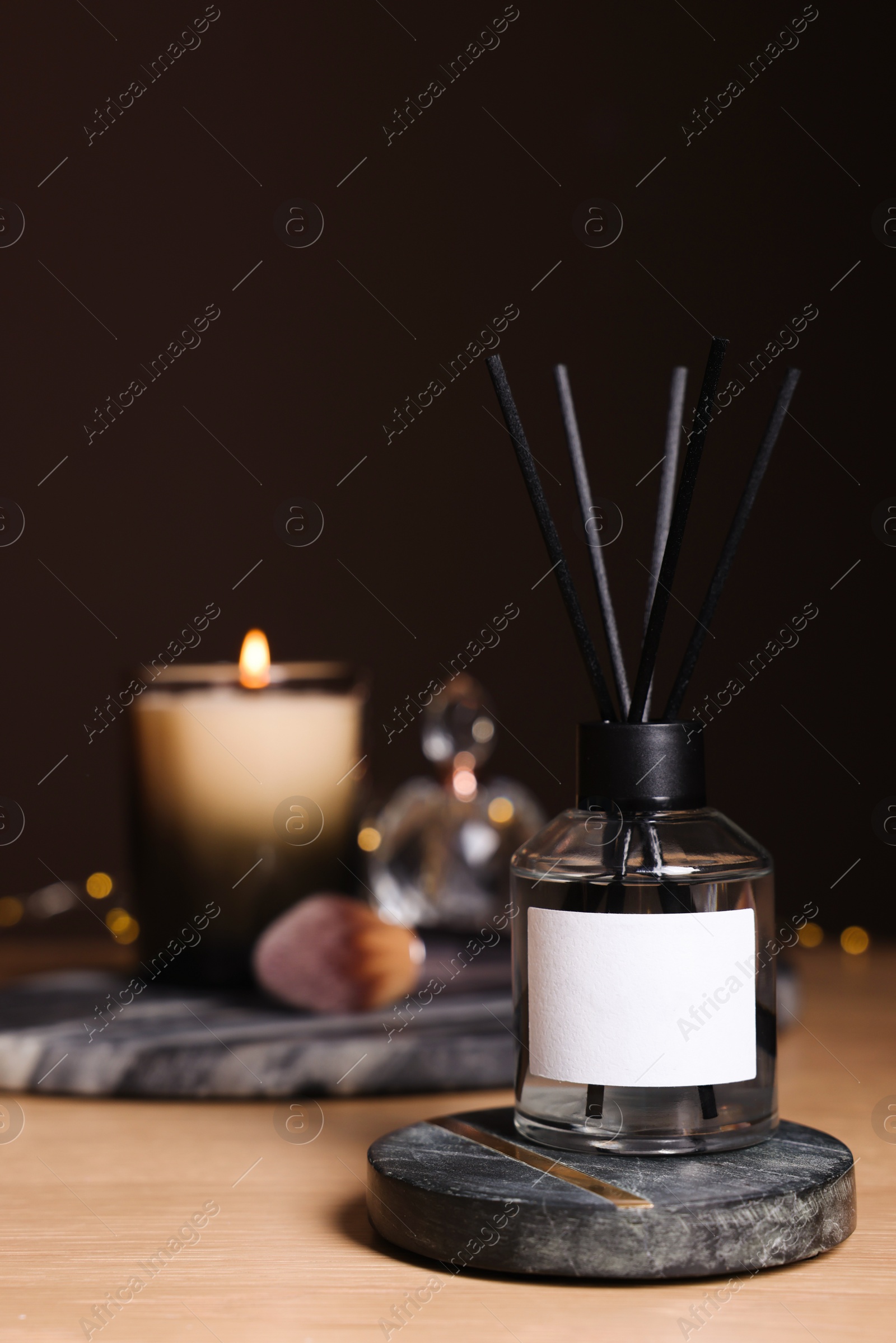 Photo of Aromatic reed air freshener on wooden table, space for text