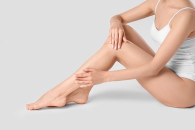 Photo of Woman with beautiful smooth legs on white background, closeup