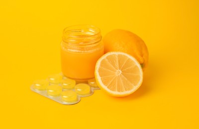 Photo of Cough drops, fresh lemons and honey on yellow background