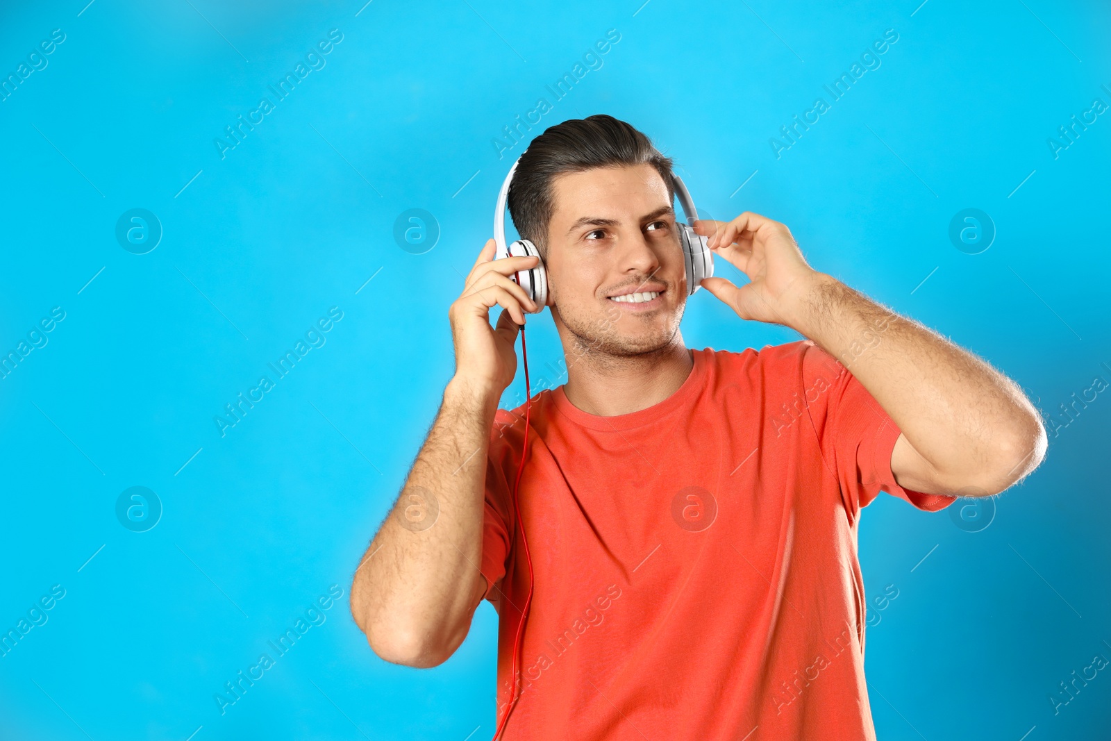 Photo of Man listening to audiobook on light blue background