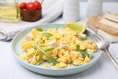 Photo of Delicious scrambled eggs with tofu and lime served on white table, closeup