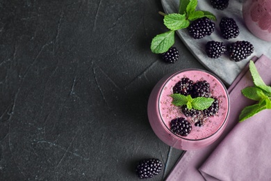 Flat lay composition with glass of delicious blackberry smoothie on black background. Space for text