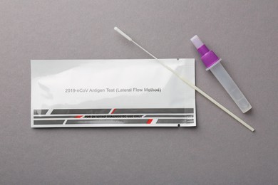 Photo of Covid-19 express test kit on gray background, flat lay