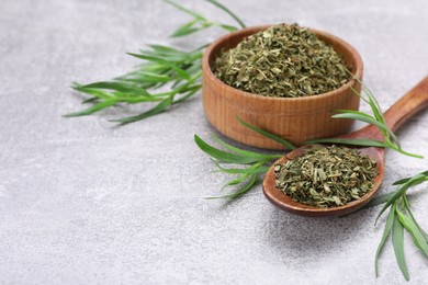 Photo of Dry and fresh tarragon on light gray textured table, space for text
